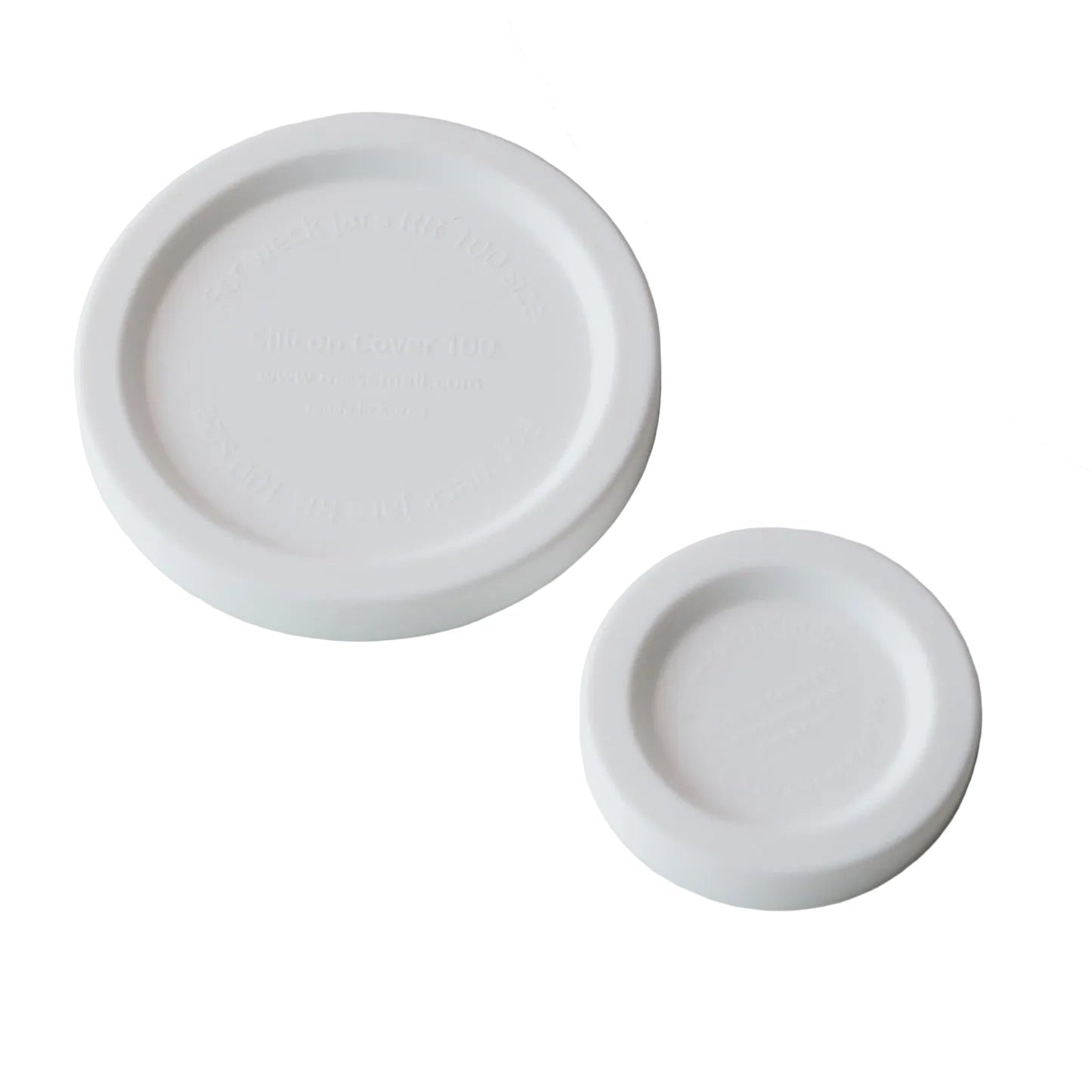 White ceramic baby bottle and two nipples on a gray background