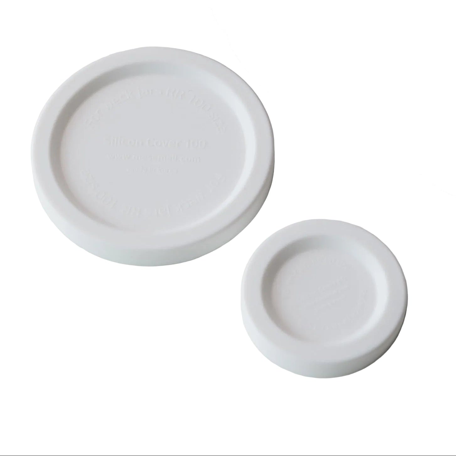 White ceramic baby bottle and two nipples on a gray background